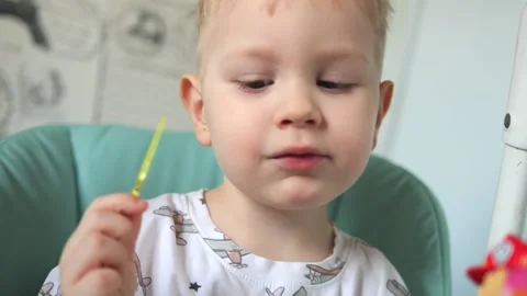 A little boy is sitting at a table and eating fruits: a banana and a pear Vidéo 267539334