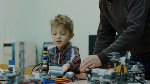 Little boy is sitting at table with construction set in room Video stock 92948005