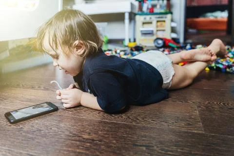 A little boy sitting at a table using a laptop Stock Photos