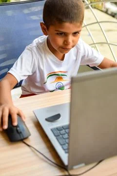 Little boy sitting at table using laptop for online class in Grade 1, Child.. Foto stock