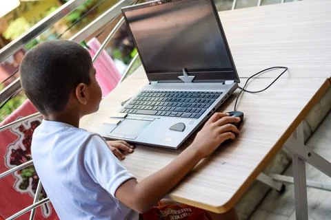 Little boy sitting at table using laptop for online class in Grade 1, Child.. Stock Photos