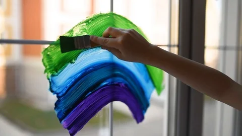 Little boy sitting at window with drawing rainbow while coronavirus quarantine Stock Footage 128901526