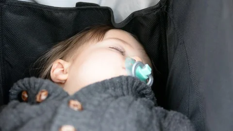 A little boy is sleep in a stroller. Close up portrait of a boy. Selective focus 動画素材 102203936
