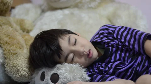 Little boy sleeping in bed on big bear doll Stockbeeldmateriaal 51239341