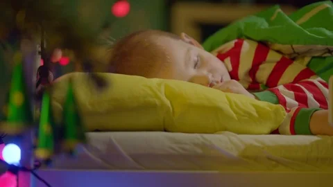 Little boy is sleeping in his cot on Christmas Eve Stock Footage 73934332