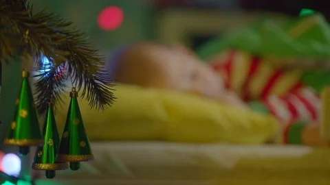 Little boy is sleeping in his cot on New Years night Stock Footage 73935899