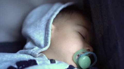 A little boy sleeps in a stroller close-up. Child with a pacifier. Stock-Footage 252129221