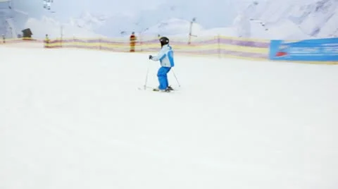 Little boy slides on alpine skis from snowy slope Stock Footage