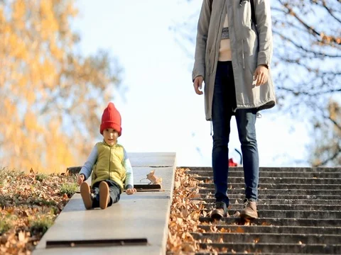 A little boy slides down and playing father in colorful clothes. Stock Footage 74005998
