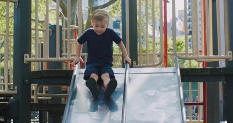 Little boy sliding down a slide at a playground Stock Footage 116113507
