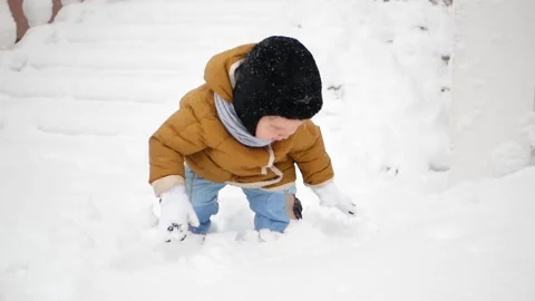 A little boy in a snowdrift, surprised by the large amount of snow Stock Footage 151880831