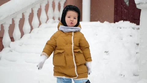 A little boy in a snowdrift, surprised by the large amount of snow Stock Footage 159392460