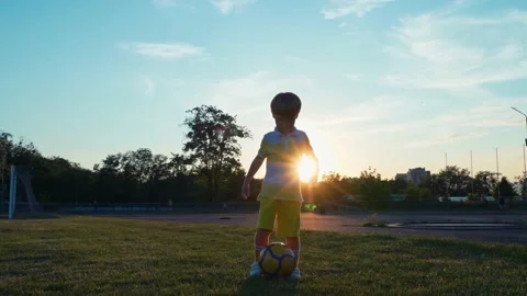 Little boy soccer player doing exercise before training on soccer field at Stock Footage 197742119