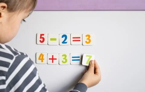 A little boy solves a difficult task. Against the background of the school bo Stock Photos