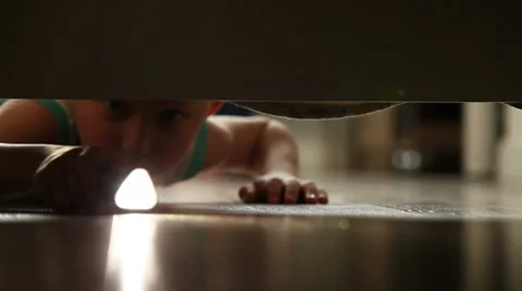 Little boy something finding under the bed with flashlight Vidéo 39565446