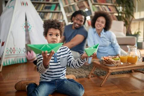 A little boy spending quality time with his parents at home. Family, home, to Stock Photos