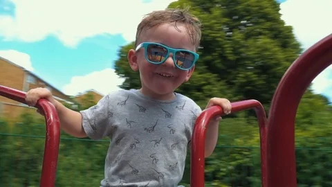 Little Boy spinning on the carousel Stock Footage 79976341
