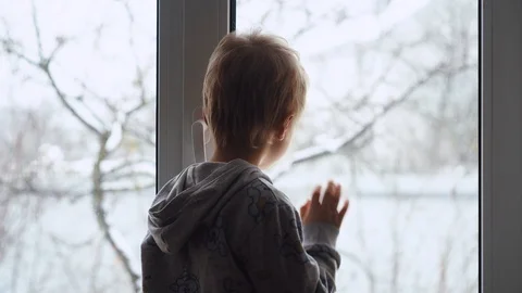 Little boy standing on a window sill,   breathing, and then drawing fingers  Stock Footage 100304057