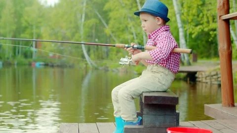Little boy in straw hat with spinning on freshwater fishing at the lake Stock Footage 78423504