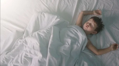 Little boy stretching in bed after wake up Stock Footage 80607867