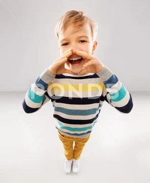 Little boy in striped pullover calling someone Stock Photos