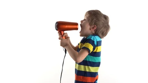 Little boy in the studio on a white background fooling around with a hairdryer Stock Footage 124228446