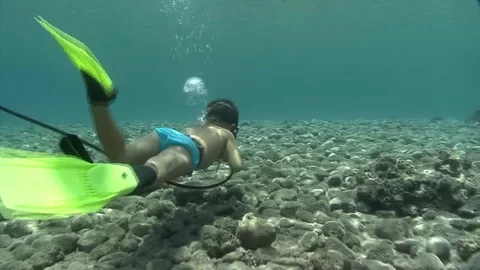 A little boy swimming underwater next to a scuba diver Stock Footage 82902053