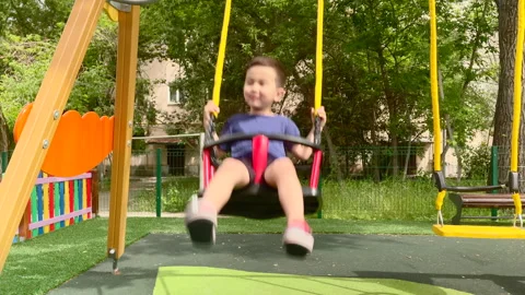 Little boy on a swing on the kids area Stock Footage 154850153
