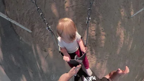 Little boy in swing at the park unique camera angle Stock Footage 140364029