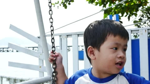 Little boy on a swing under a pine tree on the beach 스톡 동영상 60233088