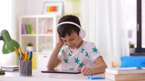 Little boy with tablet pc and headphones at home Stock Footage 89136483