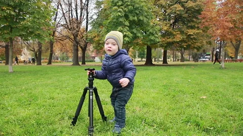 A little boy takes away a tripod Stock Footage 162777458