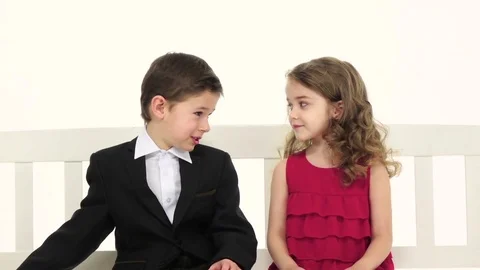 Little boy takes a pair of pants and gives the girl in return she kisses him on Stock Footage 75799331