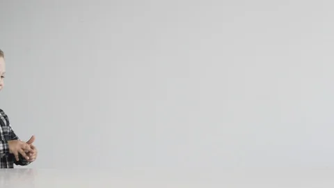 Little boy takes a plasticine machine and begins to create Stock Footage 124941689