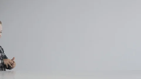 Little boy takes a plasticine machine and begins to create Stock Footage 124941723