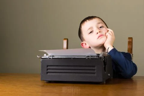 Little boy thinking in front of old typewriter Stock Photos
