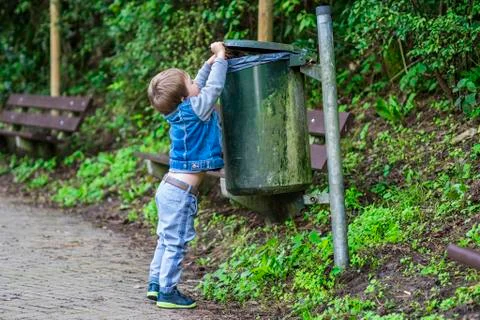 Little boy throwing trash in the bin Stock Photos