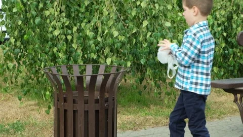 Little boy throws a biodegradable disposable bag of biomaterials in the trash. Stock Footage 251637978