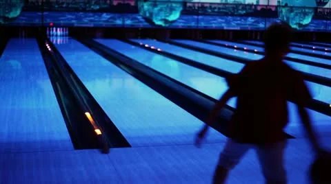 Little boy throws bowling ball and jumps Stock Footage