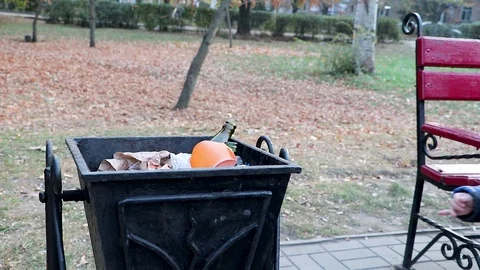 A little boy throws garbage in the trash in the street. The concept of waste man Stock Footage 97720741