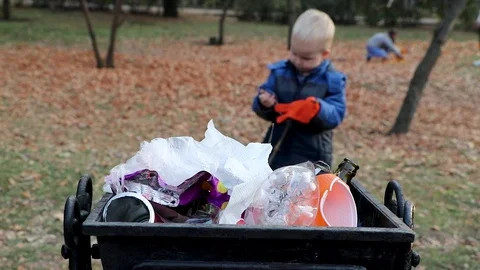 A little boy throws garbage in the trash in the street. The concept of waste man Stock Footage 97721096