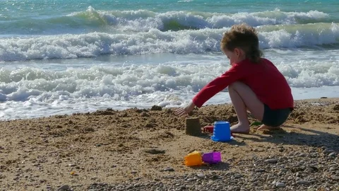 Little boy throws sand on the beach Stock Footage 78234751
