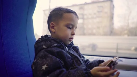 Little boy on a train with phone Stock Footage 73477530