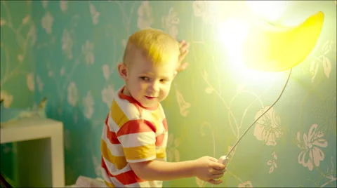 Little boy turning on and off bedside lamp Stock Footage 62730712