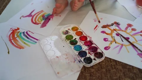 Little boy of two years old draws with paints sitting on the floor Stock Footage 168090625
