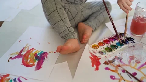 Little boy of two years old draws with paints sitting on the floor 스톡 동영상 168090853