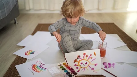 Little boy of two years old draws with paints sitting on the floor Stock Footage 168091050