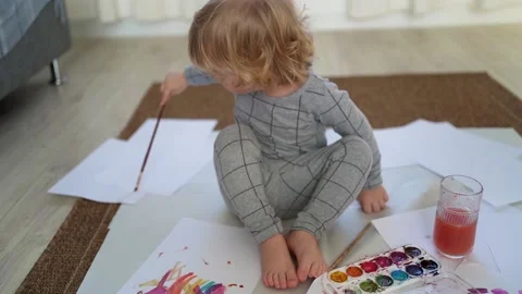Little boy of two years old draws with paints sitting on the floor Stock Footage 168091592