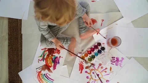 Little boy of two years old draws with paints sitting on the floor Stock Footage 168092689