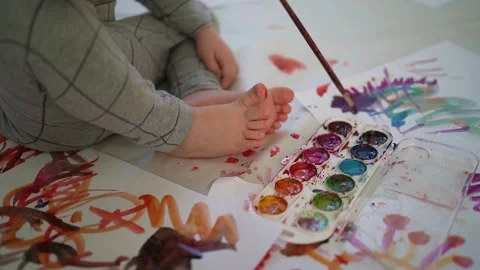 Little boy of two years old draws with paints sitting on the floor Stock Footage 168092837